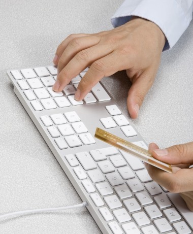 Internet Processing man inputting his credit card details from his keyboard